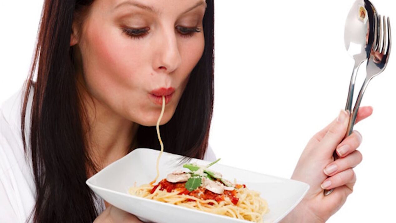 Femme mangeant des spaghettis avec un ventre mince